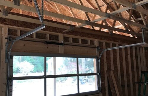 Inside view of a small overhead door in an unfinished building